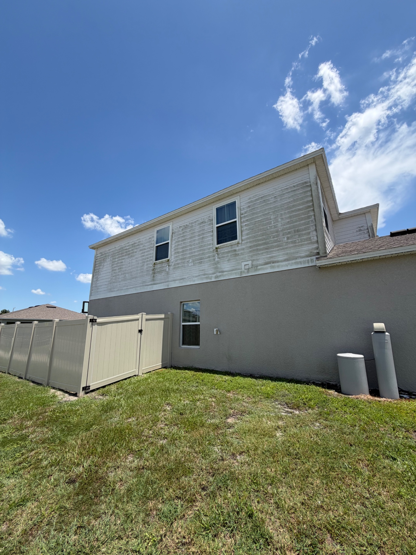 Before — algae-stained vinyl siding on Lakeland, FL home